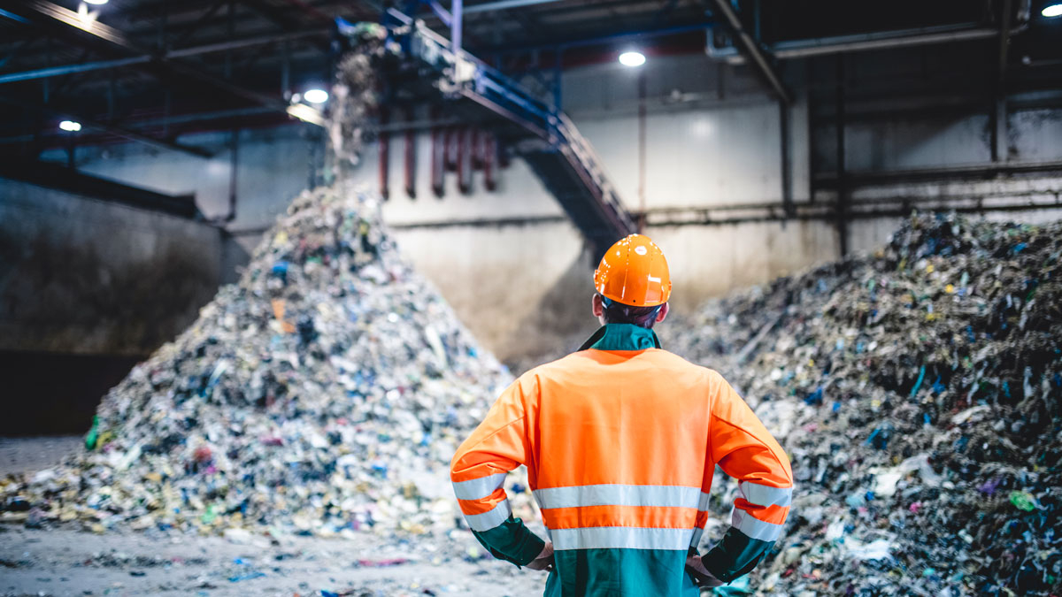 worker-from-behind-in-front-of-trash-recycling-materials