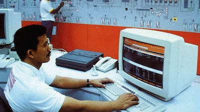 A person working in the front of a computer